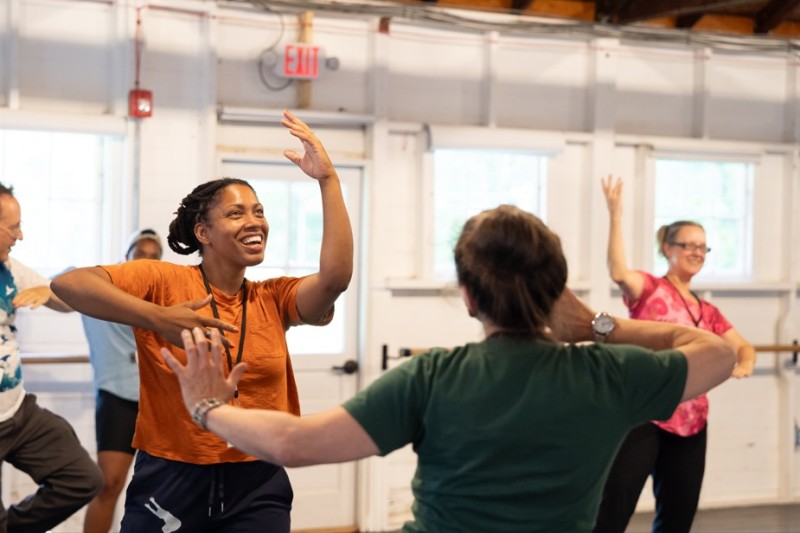 Curriculum in Motion participants dance with each other in a well lit studio