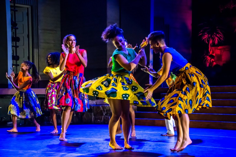 Six Dancers in Bright Colorful Costumes Dancing on Stage Spinning and Clapping Their Hands