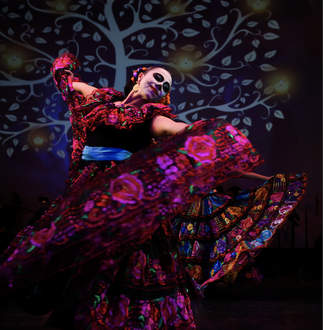 dancer in colorful traditional dress with day of the dead face painting