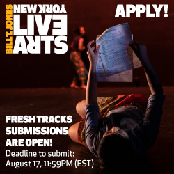 Figure laying on back on ground looking up and reading document.