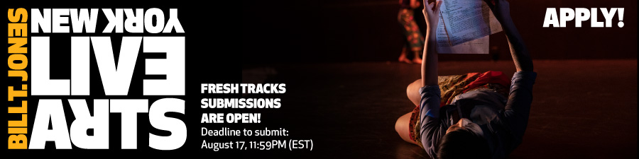 Figure laying on back on ground looking up and reading document.