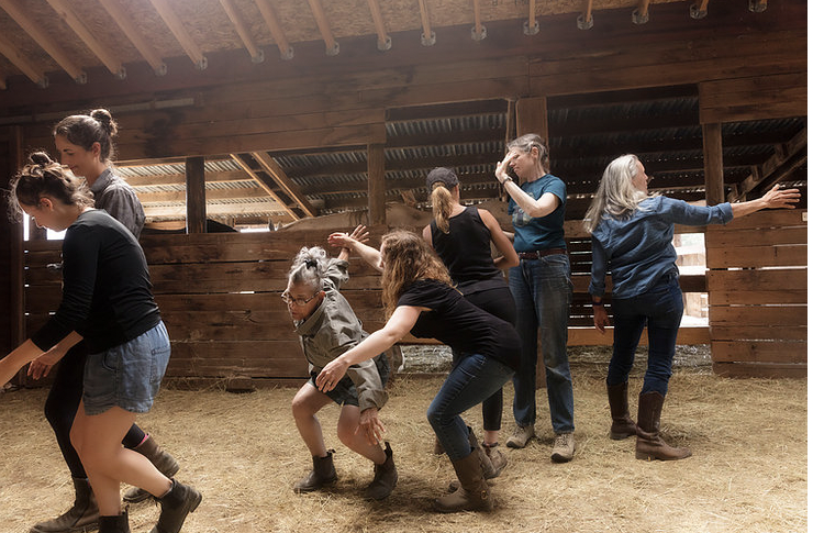 Dancers sharing space in an outdoor barn during a Physical Listening LAB.