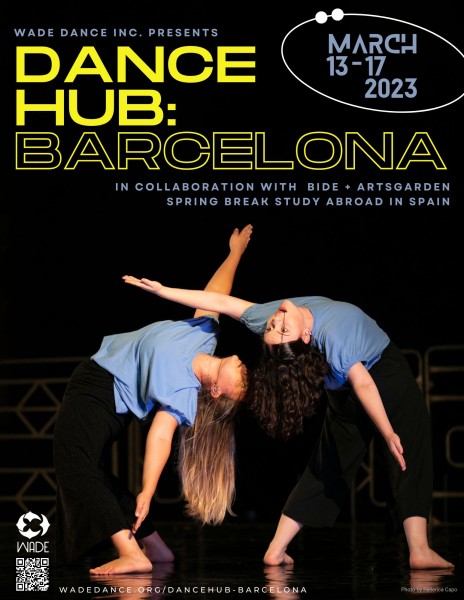 Two dancers wearing blue shirts and dark pants are arching their backs with their arms stretched out. 