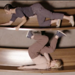 Two dancers are climbing on wooden pews. 