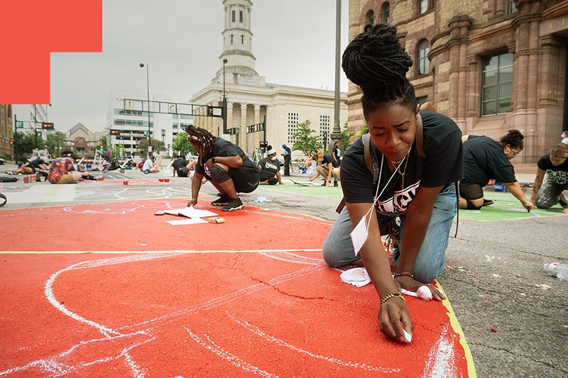 Person drawing with chalk on the ground. 