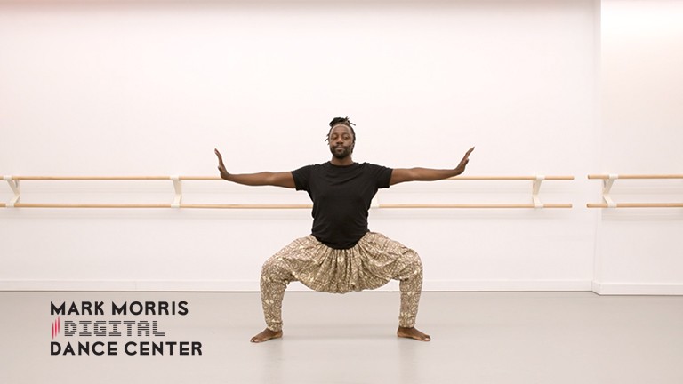 a man in plie with outstretched arms dancing in a studio