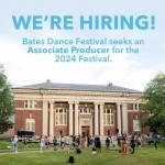 A photo of a large brick building on green grass, surrounded by a crowd.