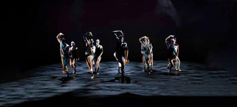 Dancers on stage w/ a dark background, lights on dancers