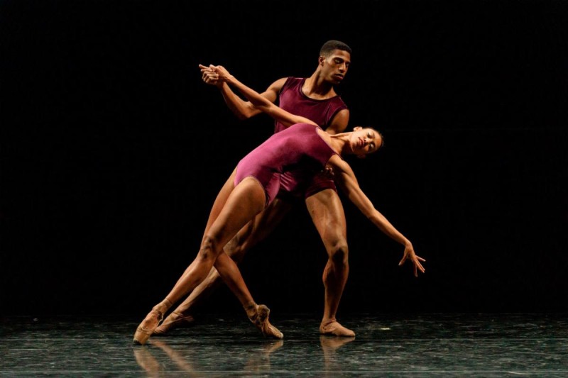 Two company dancers in fuchsia leotards on stage