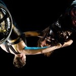 A close up of Alice Sheppard and Laurel Lawson suspended in the air, arms outstretched and clasping each other&rsquo;s hands. 