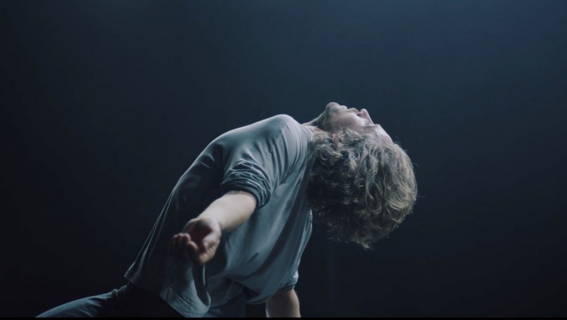 Dancers on stage, dressed in grey