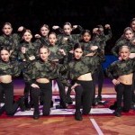Dancers on Brooklyn Nets court in green tops and black pants.