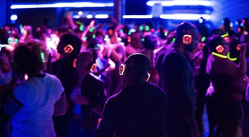 People at a Silent Disco Party dancing and wearing different colored headphones listening to music