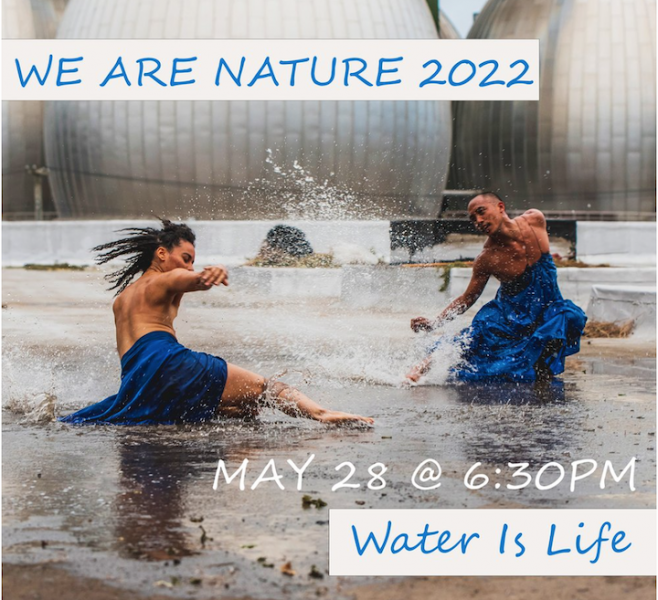 Two people wearing blue skirts dancing in the rain water on an industrial gray concrete rooftop