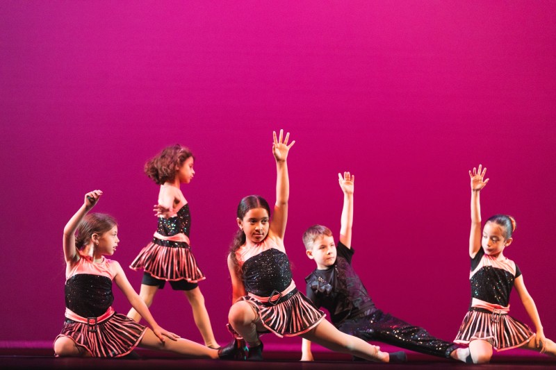 group of 5 young dancers in a jazz dance pose and wearing pink and black sequins 
