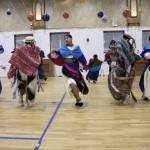 A group of dancers dancing energetically in an auditorium