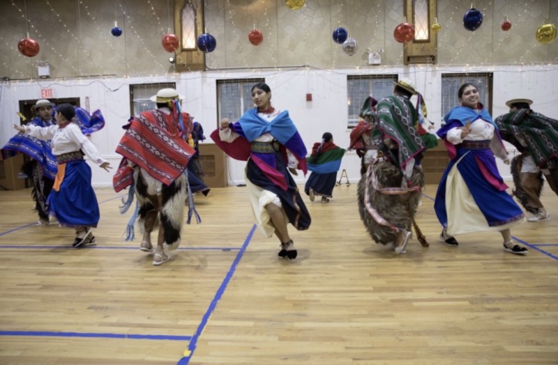 A group of dancers dancing energetically in an auditorium