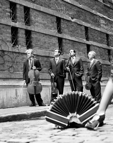 Image of the bandoneon with the Cuartetango string quartet in the background.  