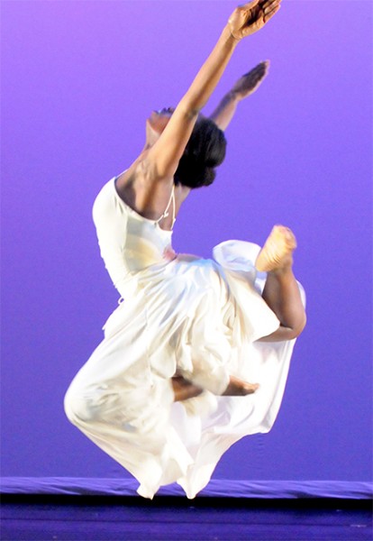 Dancer in the air against a purple backdrop