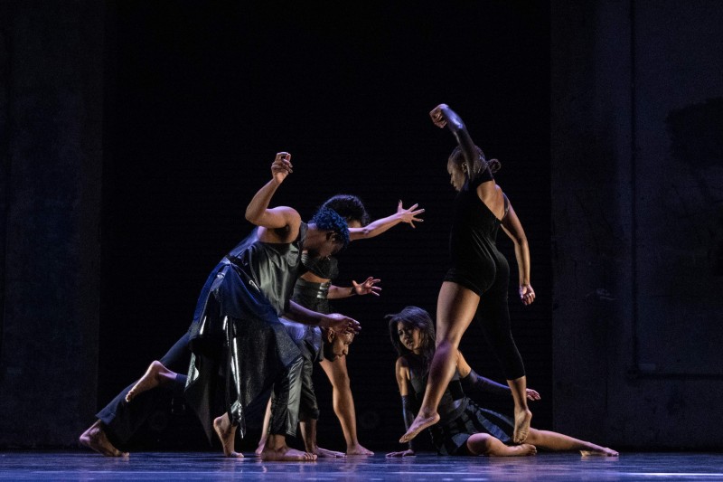 Group of dancers on stage coming in to a circle, arms raised