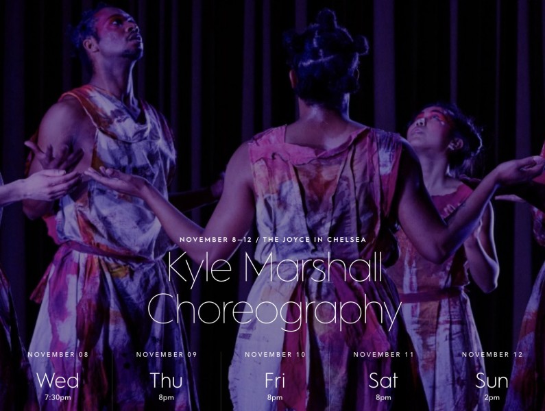 Photo of dancers in painted tunics gathered in a circle, looking up