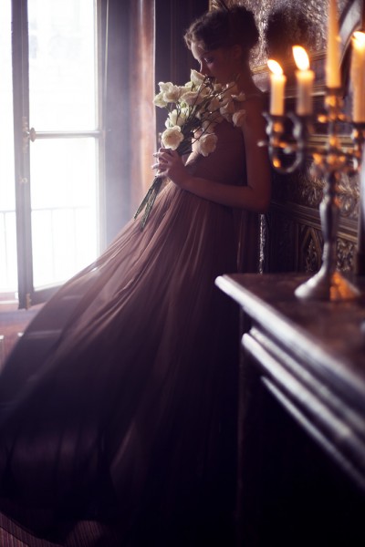 beautiful young woman in darkk romantic french ballroom