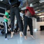 Four dancers are captured mid jump