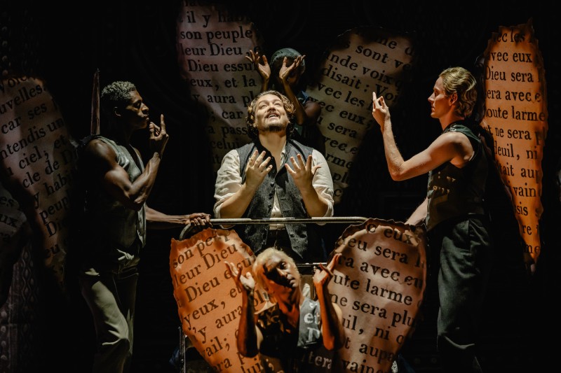 4 dancers dressed as angels encircle a central figure, a tenor, who looks longingly to the heavens