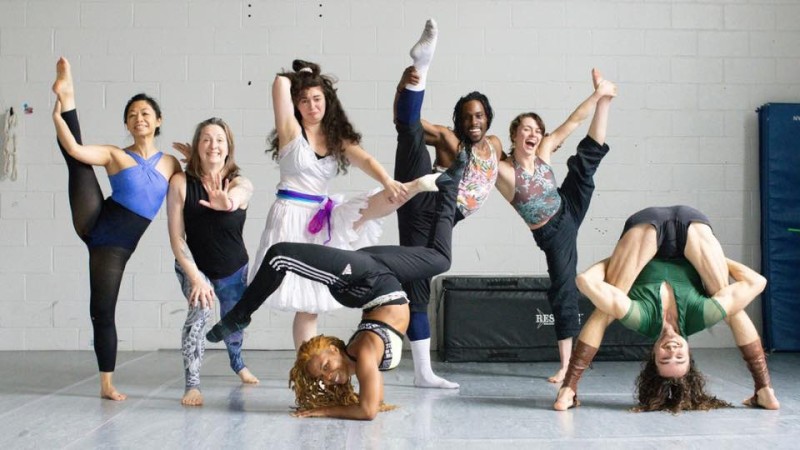seven exuberant artists strike silly acrobatic poses in the circus studio 