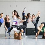 a group of 7 circus artists make silly poses standing in the studio