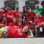 Group of 16 Volunteers and Staff from Formation Team wearing 2025 Red Commemorative tshirts posing for a photo after the parade