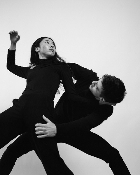 Dancers dressed in black are moving.