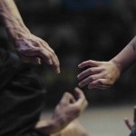 two hands extended to reach one another 