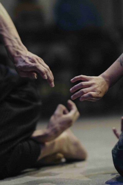 Two hands reach towards one another, the fingers slightly bent.