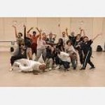 A group of student dancers gathered in a City Center studio in a group pose.
