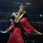 Two dancers lift another dancer in the air.