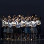 A group of dancers lifts their right arms