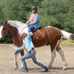 Two women with a horse, one dancing one riding