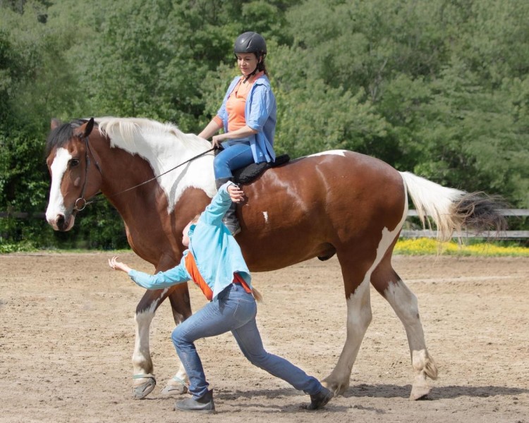 Two women with a horse, one dancing one riding