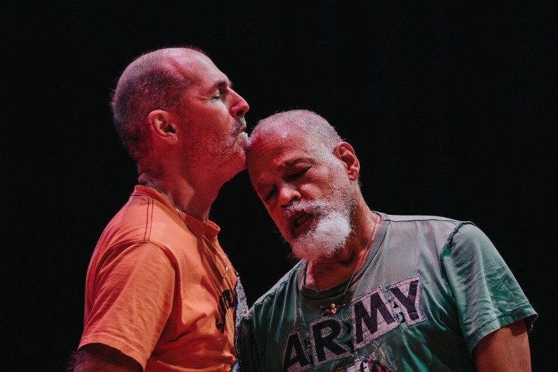 Keith and Ishmael dancing together: two queer elders rest their heads on each other with eyes closed.