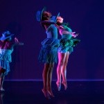 Four Red Clay Dance Company members in blue costumes. Two are jumping. Two are running.