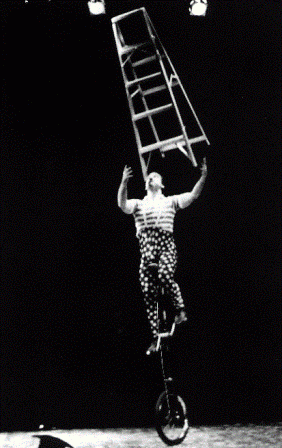Performer riding a unicycle while balancing a ladder on their chin and juggling at the same time.