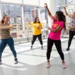 Dancers in colorful outfits in a large studio