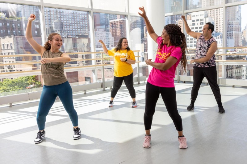 Dancers in colorful outfits in a large studio
