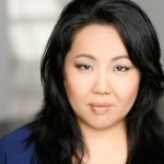 Close up of a woman with long black hair and a blue shirt