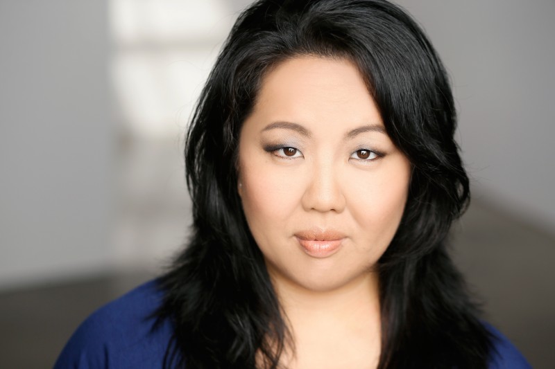 Close up of a woman with long black hair and a blue shirt