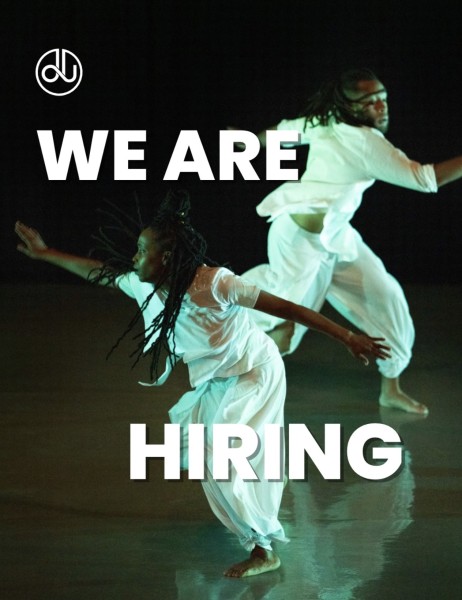 A photo of two dancers in motion wearing all white. Text on the screen says &ldquo;We are hiring&rdquo; along with the Company Logo