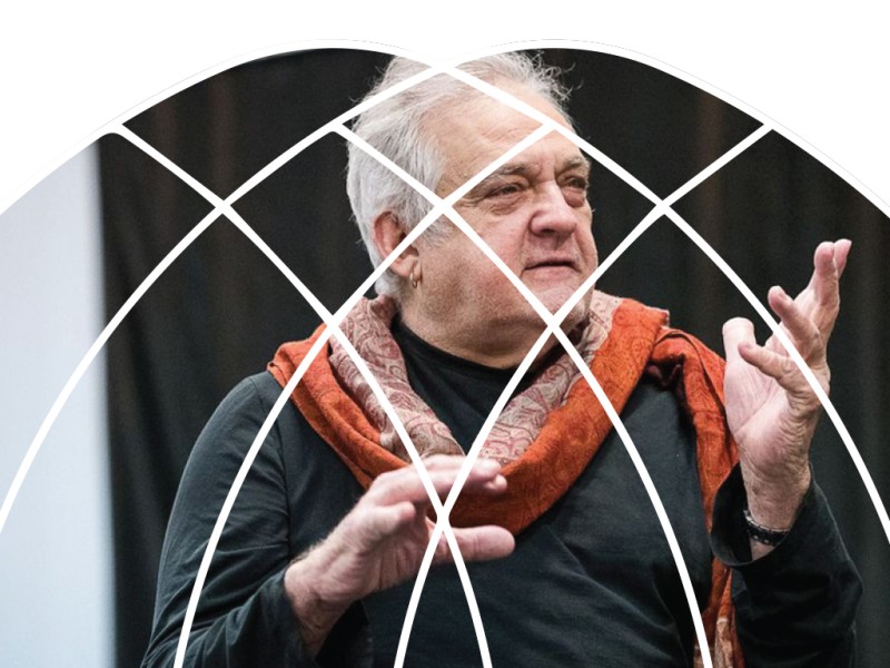 Mark Morris is framed in a semi-circular lattice design. He appears to be speaking while gesturing with his hands.