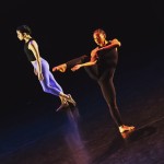 One dancer standing on one leg, holding working leg in side attitude position.