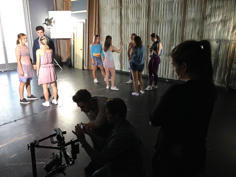 Dancers on a film set, standing while framing the shot